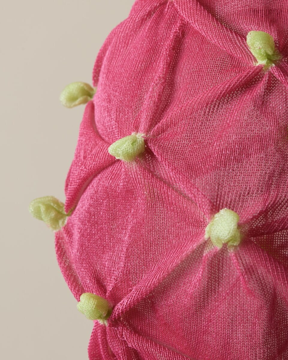 a detail of a suspended pink-and-green textile lamp shade