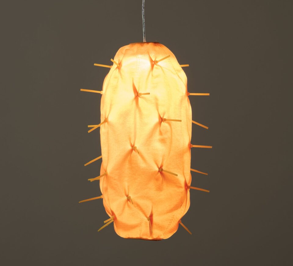 a detail of a suspended orange lamp abstractly reminiscent of a tropical fruit
